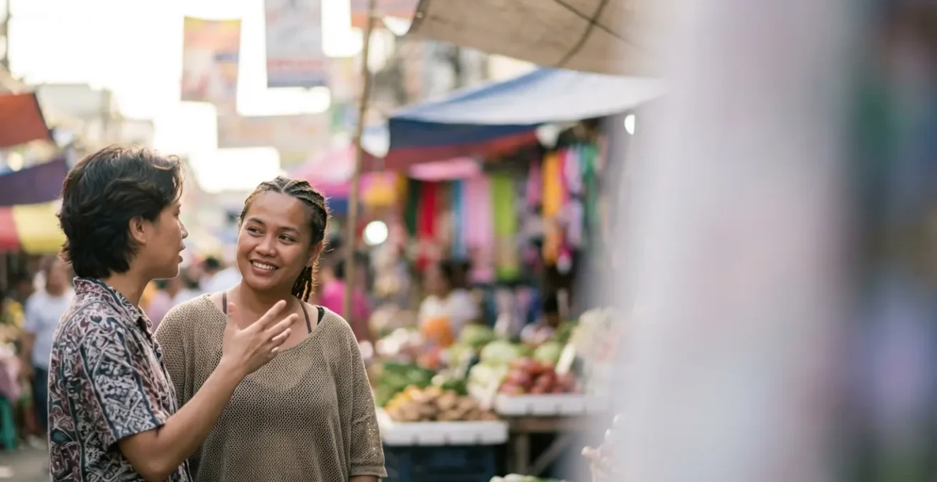 A warm interaction between a Filipino traveler and a local Filipino person engaged in friendly conversation in a casual setting.