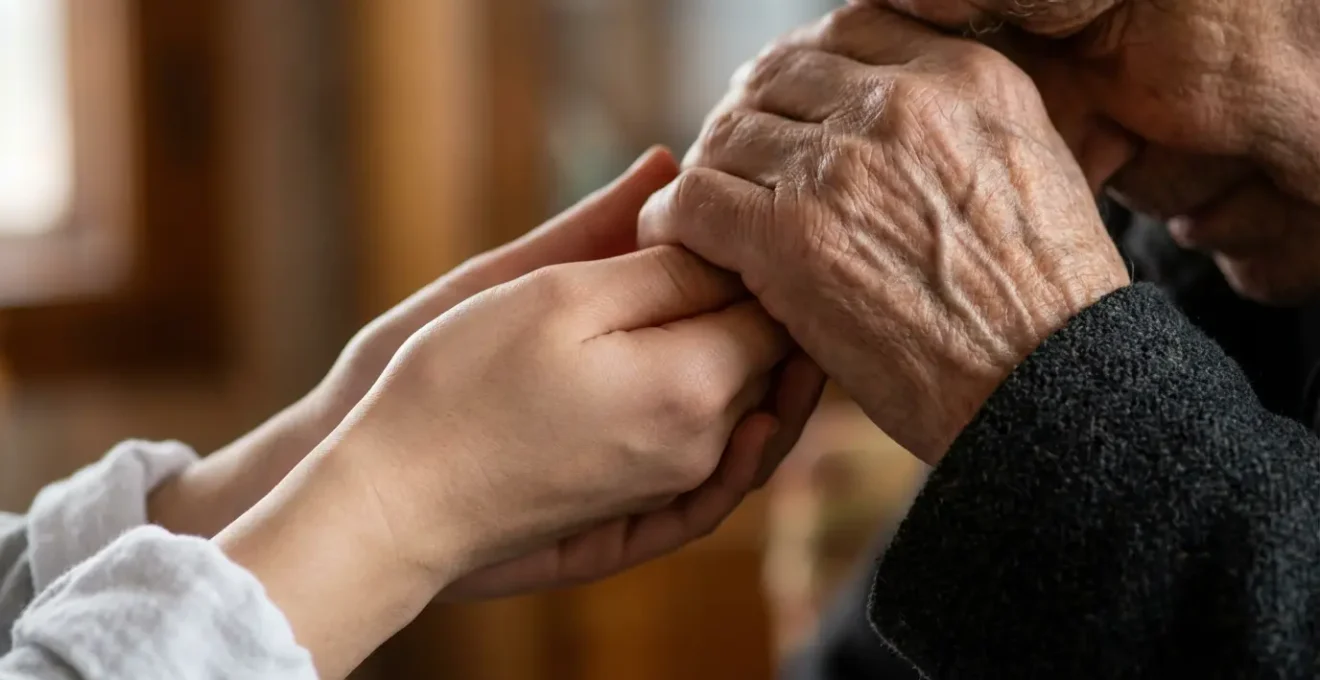 A young person performing the traditional Mano Po gesture with a Filipino elder in a home setting