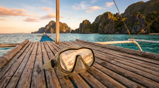 Crystal clear snorkel mask being prepared on a boat deck with tropical Philippine islands in the background